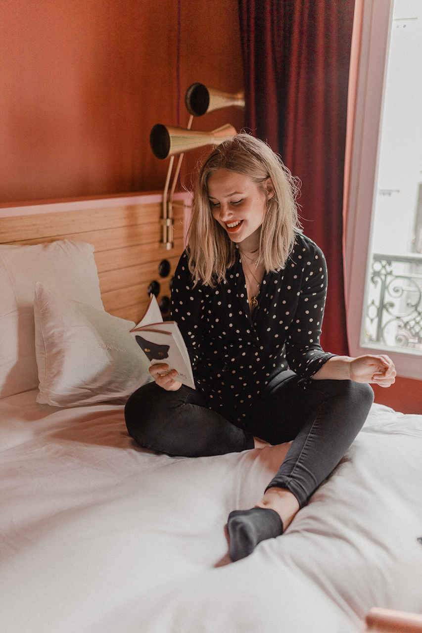 Blogger Sarah Witpeerd reading a poetry book at the 25 Hours Hotel Terminus Nord, Paris