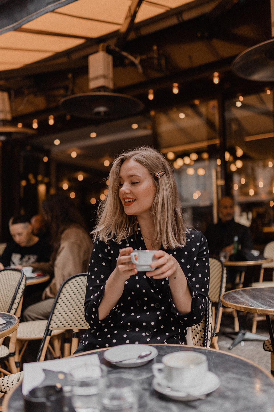 Blogger Sarah Witpeerd sitting at a Parisian cafe